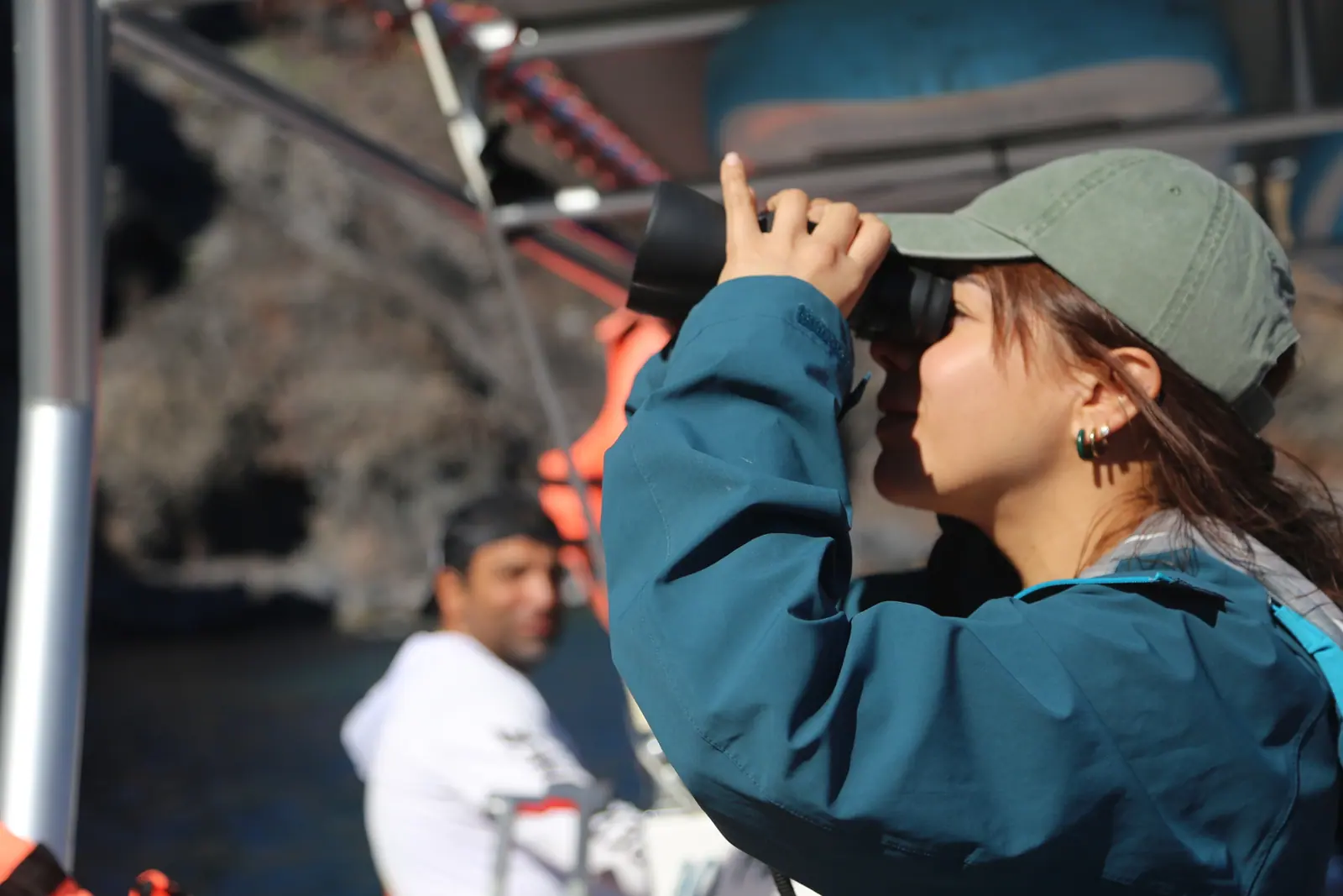 a person on the boat using the binoculars to see the blue footed boobies